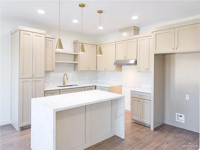 a kitchen with kitchen island white cabinets and refrigerator