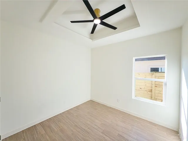 an empty room with a window and a fan