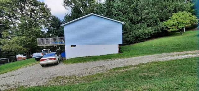 a front view of a house with a garden and trees