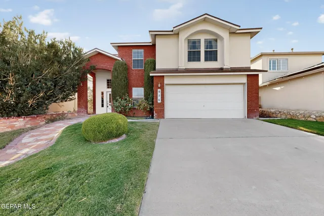 a front view of a house with a yard and garage