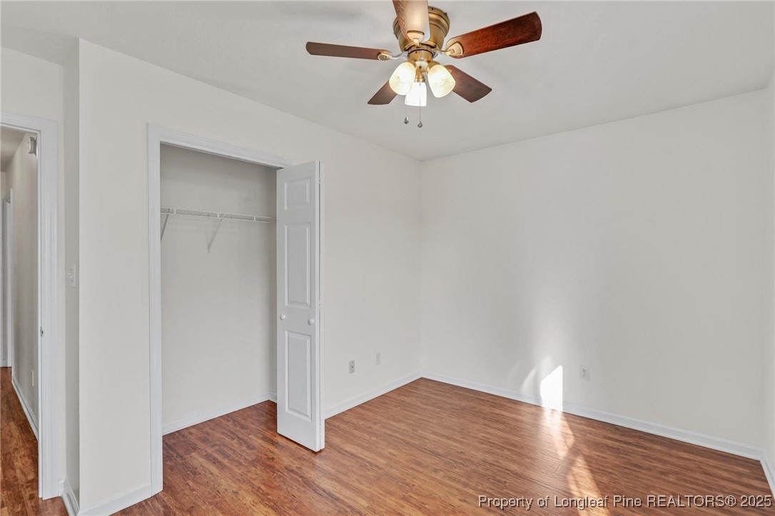 317 Kernstown Road Raeford, NC 28376 - Photo 27 of 32 an empty room with wooden floor fan and windows