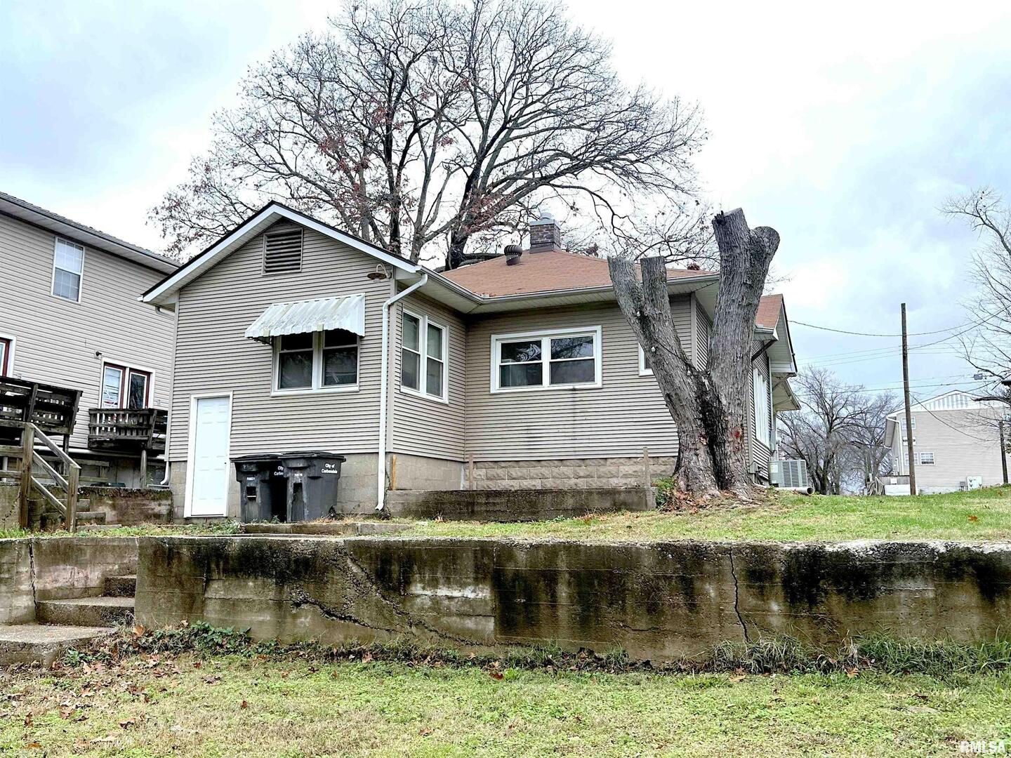 405 West College Street Carbondale, IL 62901 - Photo 15 of 18 a view of a house with a yard large pool and a large tree