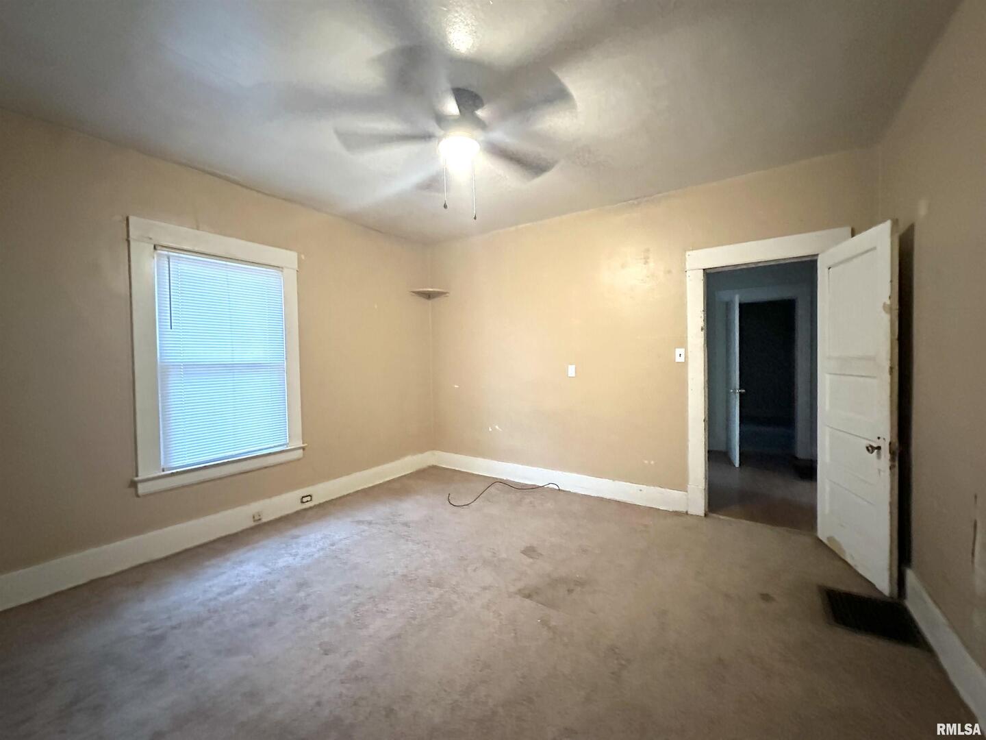 405 West College Street Carbondale, IL 62901 - Photo 9 of 18 an empty room with a chandelier fan and windows