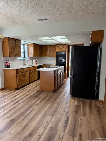 a view of a livingroom with wooden floor and a ceiling fan