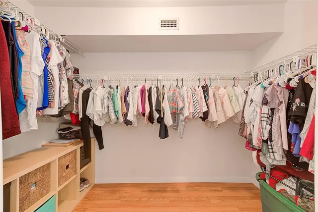 a walk in closet with clothes