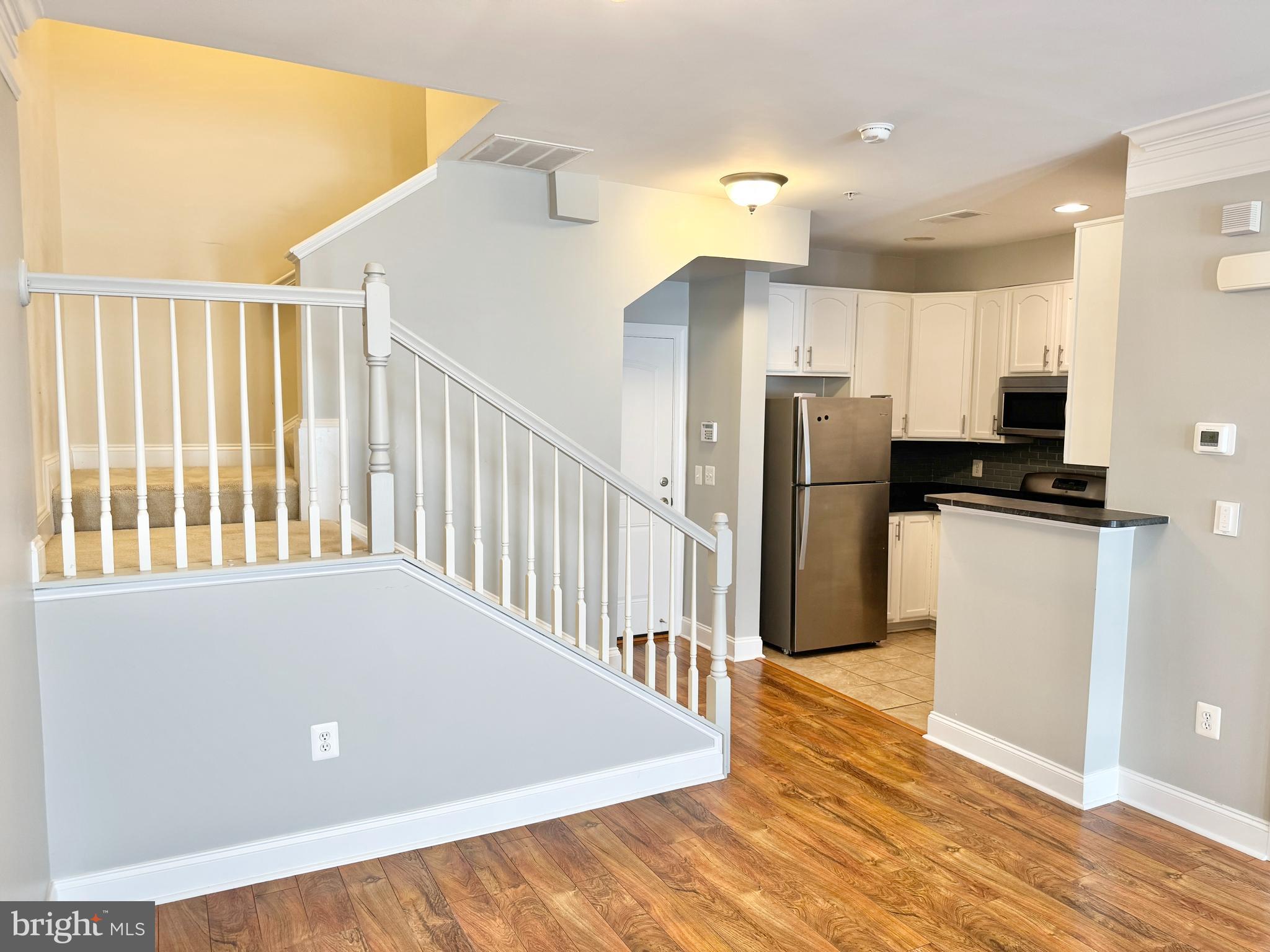 2304 Margraf Circle Woodbridge, VA 22191 - Photo 6 of 27 a hallway with stainless steel appliances a refrigerator and wooden floor