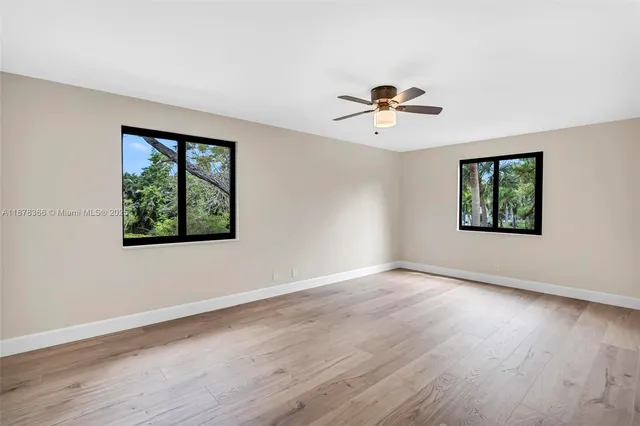 a view of an empty room with a window and a flat screen tv