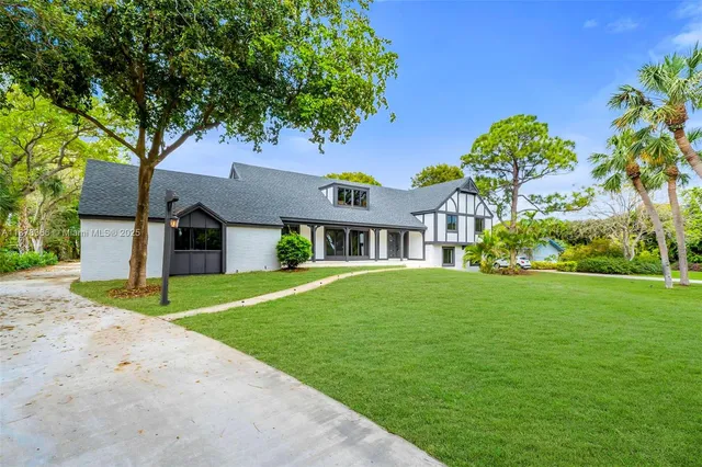 a front view of a house with a garden and plants