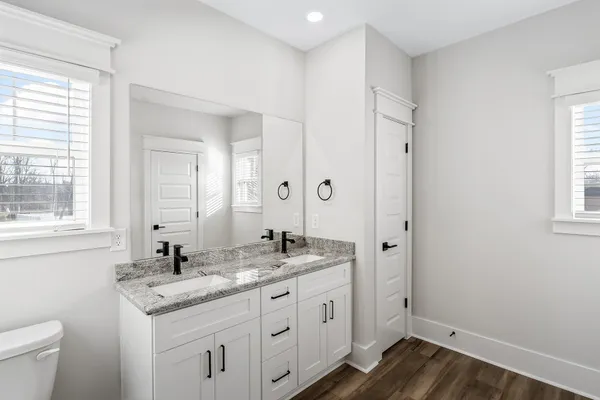 a bathroom with a granite countertop sink mirror and a toilet