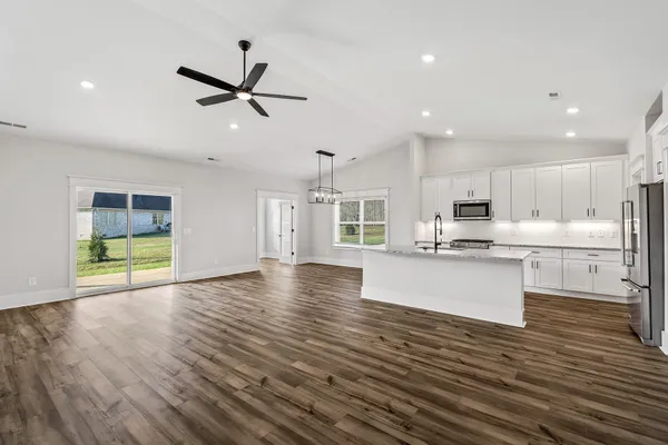 a view of kitchen with cabinets appliances and wooden floor