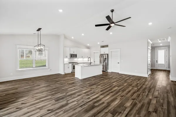 a view of a kitchen with wooden floor and a ceiling fan