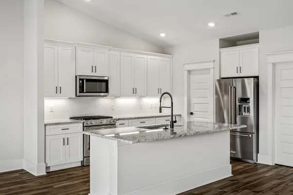 a kitchen with kitchen island a counter top space cabinets and stainless steel appliances