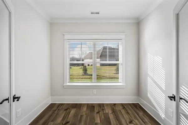 a view of a room with wooden floor and windows