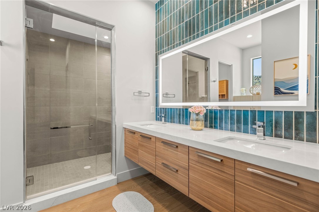 571 Overlook Rim Drive Henderson, NV 89012 - Photo 35 of 85 Bathroom with double vanity, a stall shower, light wood-style floors, backsplash, and recessed lighting