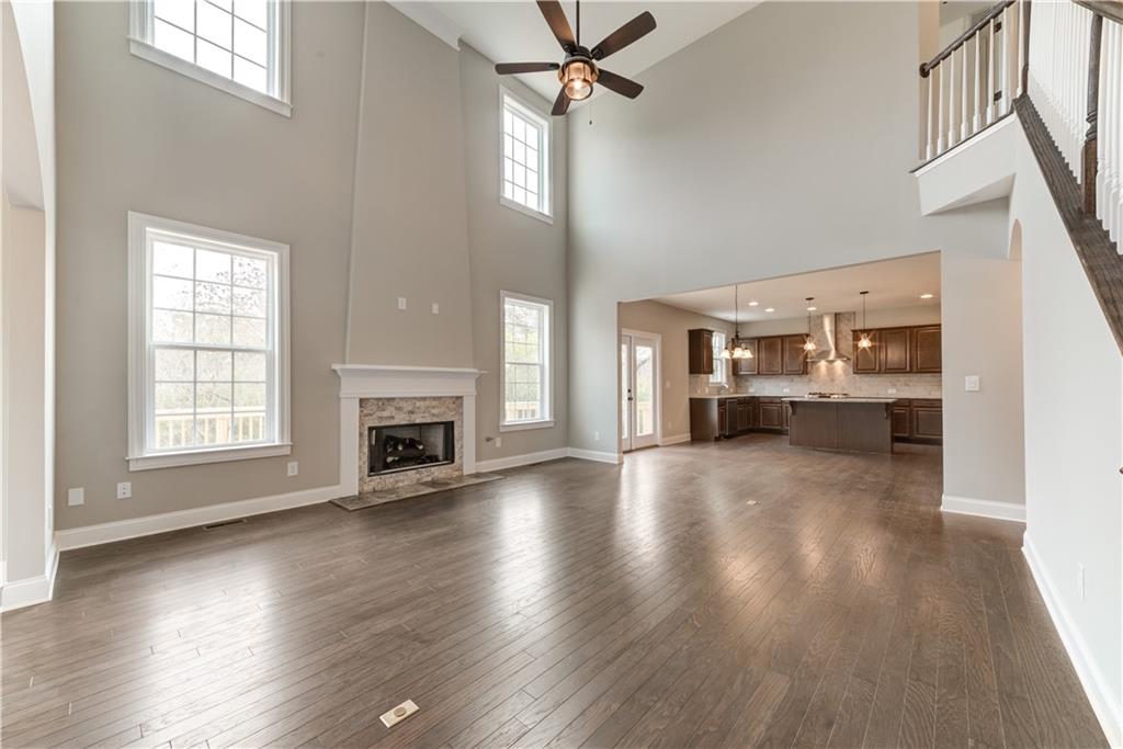 6145 Grindle Road Cumming, GA 30041 - Photo 11 of 20 an empty room with wooden floor a ceiling fan and windows
