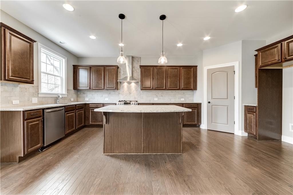 6145 Grindle Road Cumming, GA 30041 - Photo 13 of 20 a large kitchen with stainless steel appliances kitchen island granite countertop a stove a sink and a microwave