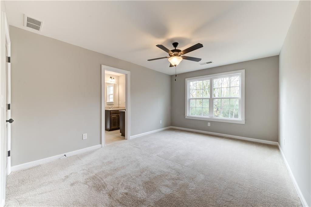 6145 Grindle Road Cumming, GA 30041 - Photo 16 of 20 an empty room with chandelier fan and windows
