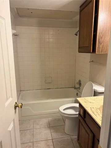 a bathroom with a granite countertop bathtub toilet and sink