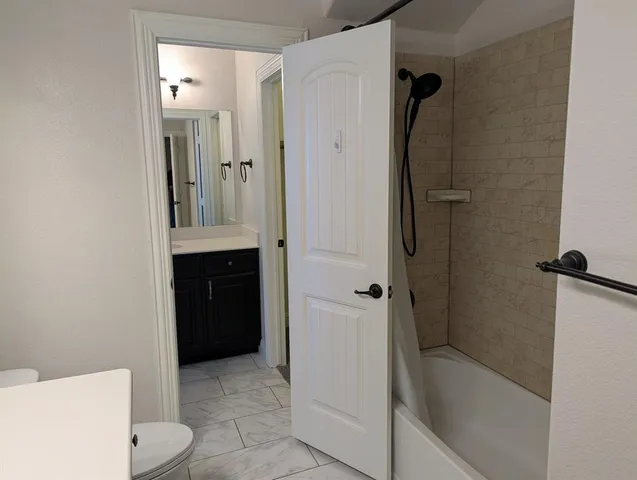 a bathroom with a granite countertop sink toilet and shower