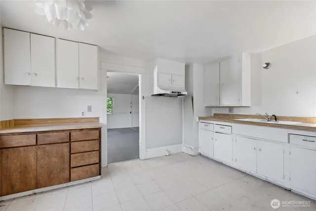 a kitchen with white cabinets and a sink