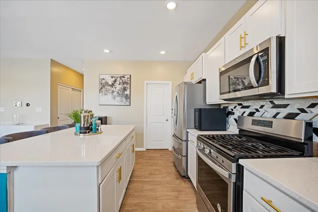a kitchen with a table chairs sink and cabinets
