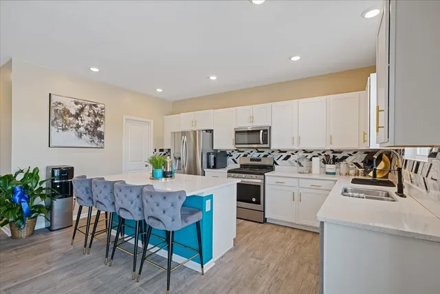a kitchen with a dining table chairs and white cabinets