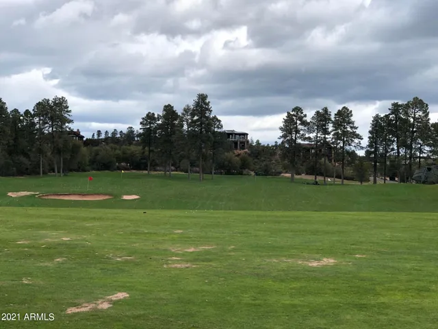 a patio with a table and chairs under an umbrella with a barbeque grill and plants