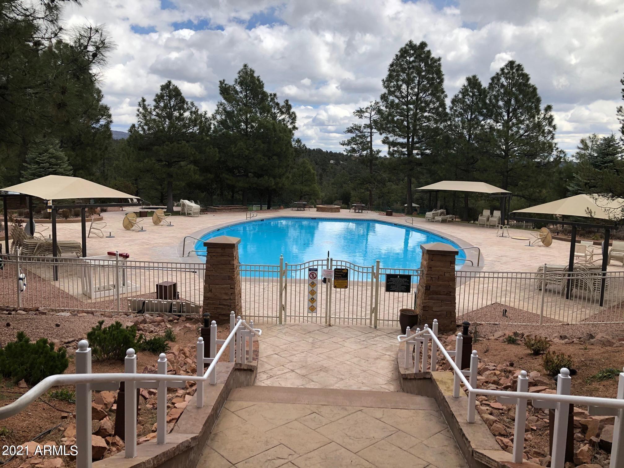 603 Club Drive, Unit 3 Payson, AZ 85541 - Photo 23 of 25 a patio with a table and chairs under an umbrella with a barbeque grill and plants