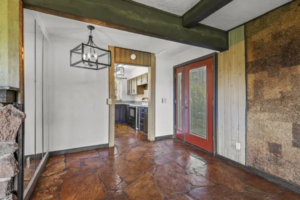 a view of a hallway with wooden floor and a kitchen