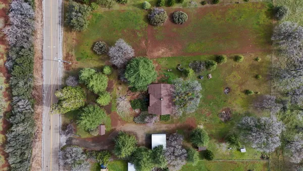 an aerial view of a house with a yard