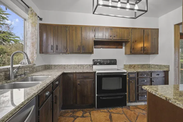 a kitchen with stainless steel appliances granite countertop a sink stove and refrigerator