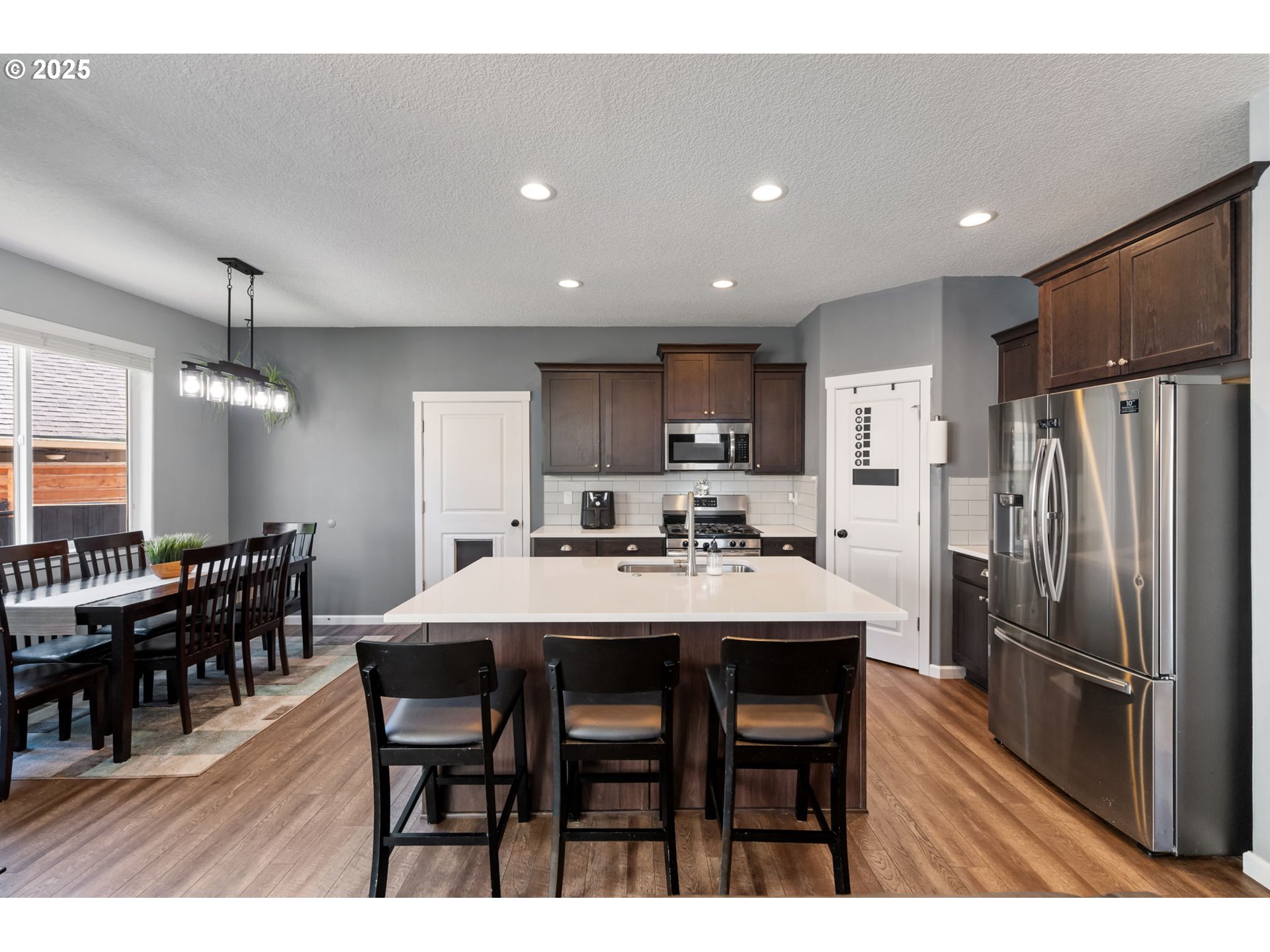 2820 Southeast Baker Avenue Gresham, OR 97080 - Photo 6 of 33 a kitchen with counter space dining table and stainless steel appliances