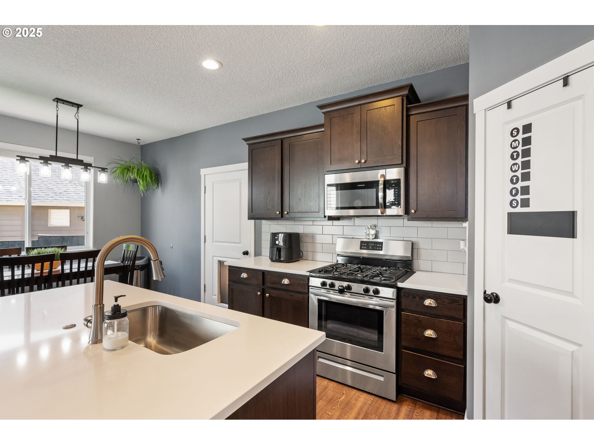 2820 Southeast Baker Avenue Gresham, OR 97080 - Photo 7 of 33 a kitchen with stainless steel appliances a stove a sink a microwave a refrigerator and cabinets