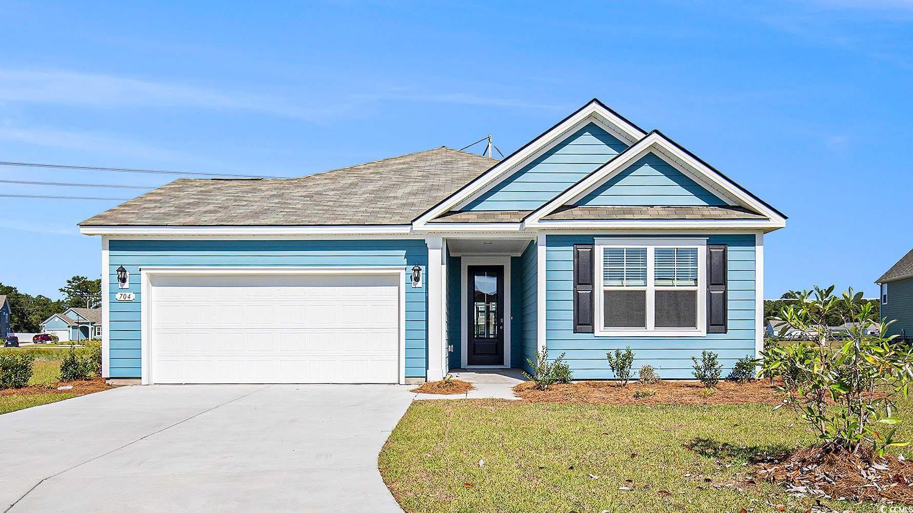 View of front of house featuring concrete driveway, a front lawn, and an attached garage