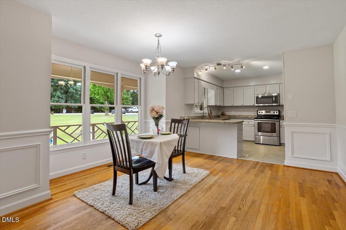 805 Rand Road Garner, NC 27529 - Photo 21 of 38 a view of a dining room with furniture a chandelier and wooden floor