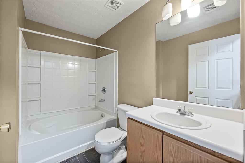 3303 Par 3 Way Lithonia, GA 30038 - Photo 17 of 27 a bathroom with a sink a toilet and shower