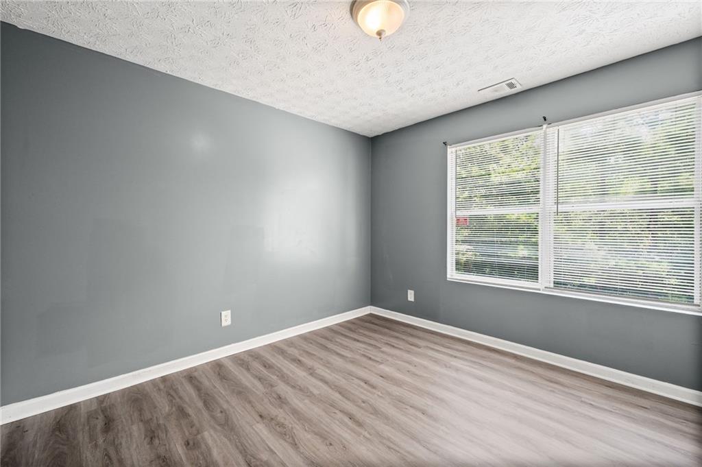 3303 Par 3 Way Lithonia, GA 30038 - Photo 18 of 27 an empty room with wooden floor and windows