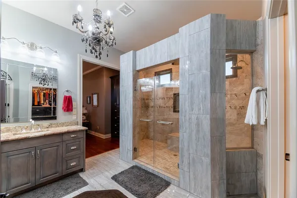 a spacious bathroom with a granite countertop sink a mirror and shower