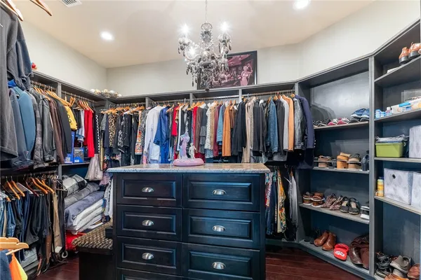 a view of walk in closet with clothes and shoes