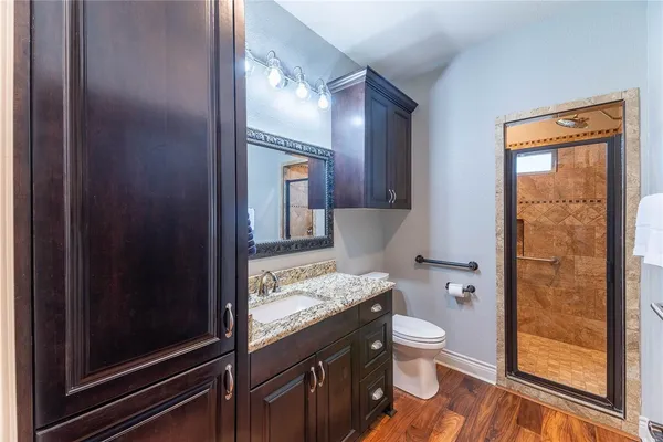 a bathroom with a granite countertop sink toilet and shower