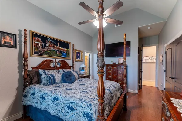 a bedroom with bed and a flat tv screen on dresser