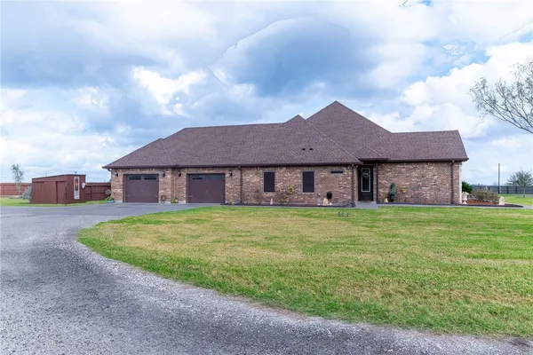 a view of a big house with a big yard and large trees