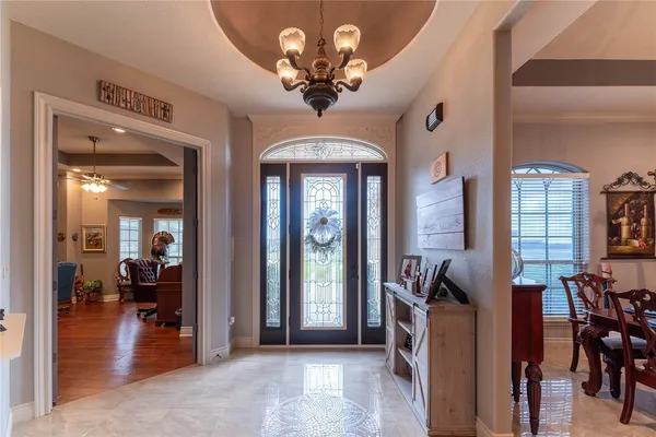 a view of a livingroom with a dinning area hardwood floor a chandelier