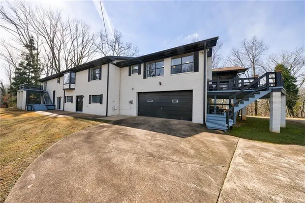 a open kitchen with stainless steel appliances kitchen island granite countertop a table chairs and white cabinets