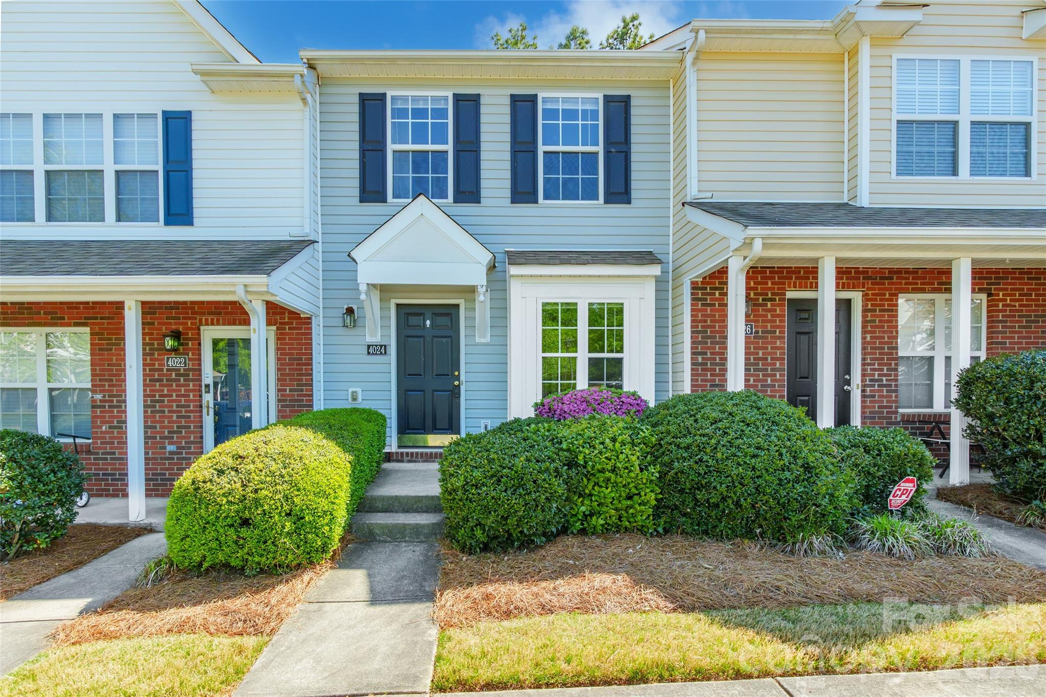 front view of a brick house with a yard