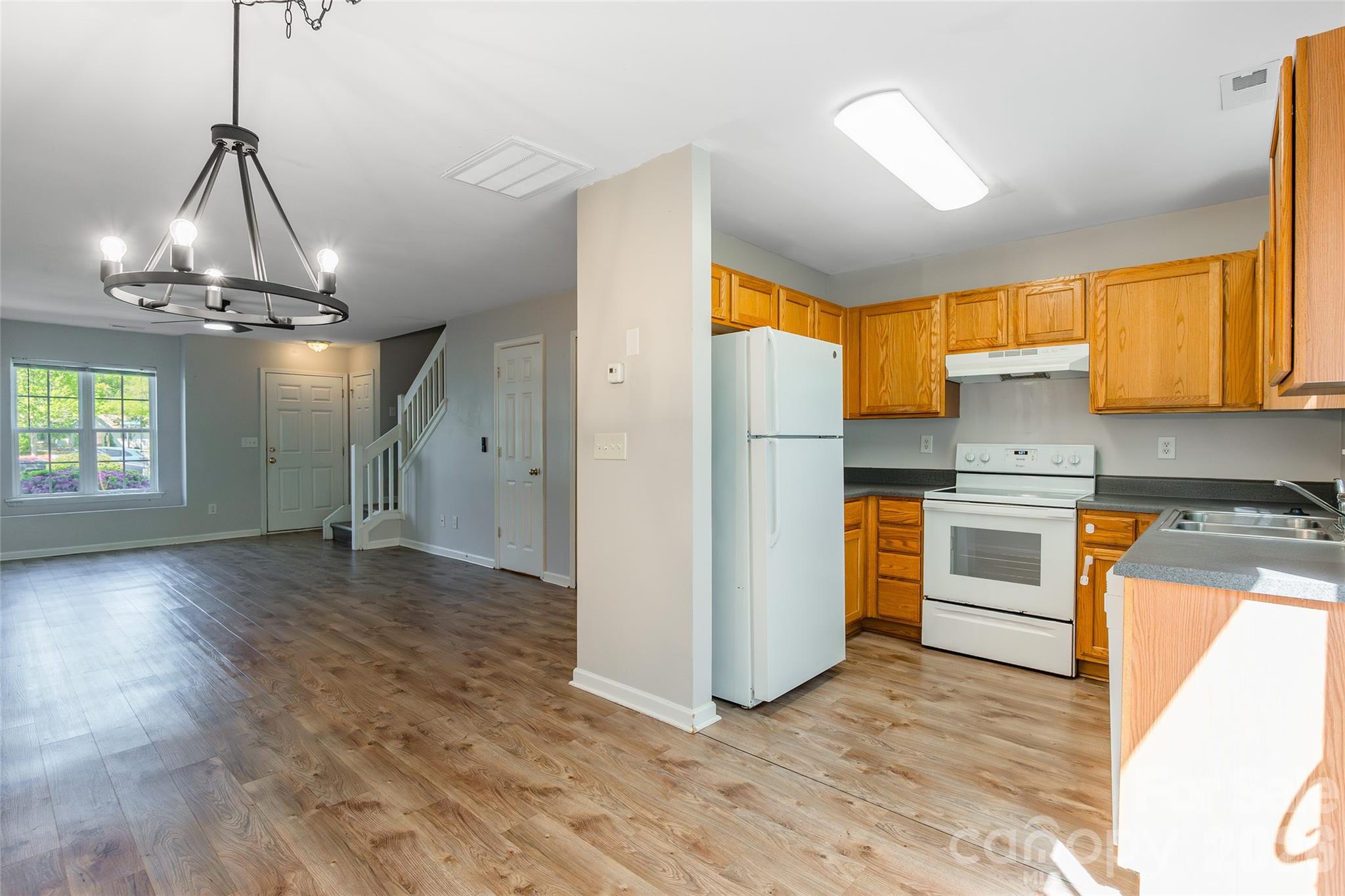 4024 Ashby Lane Fort Mill, SC 29707 - Photo 6 of 21 a view of a kitchen with a sink wooden floor oven and cabinets