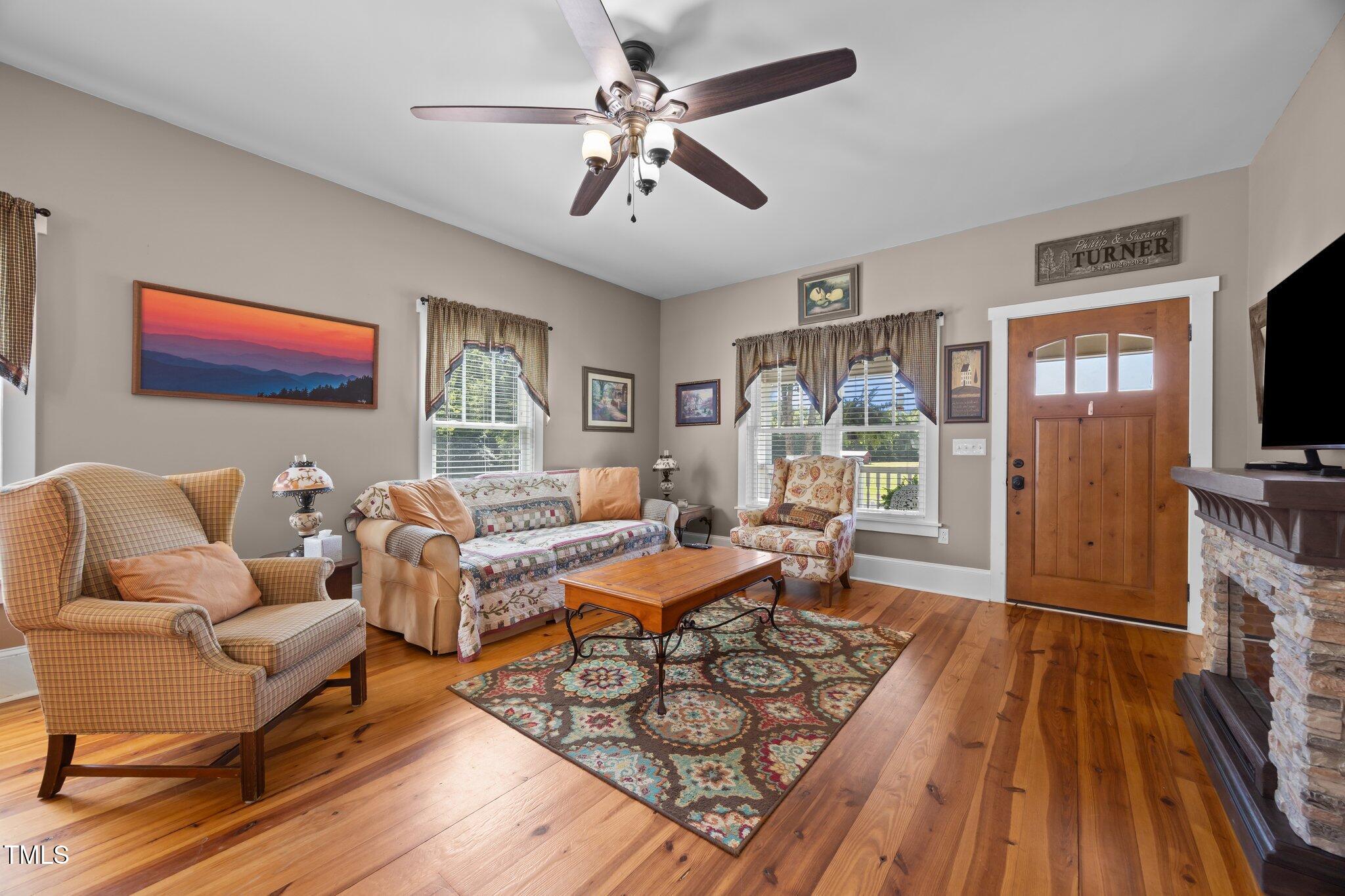 4050 Culbreth Road Stem, NC 27581 - Photo 14 of 46 a living room with furniture a flat screen tv and a fireplace