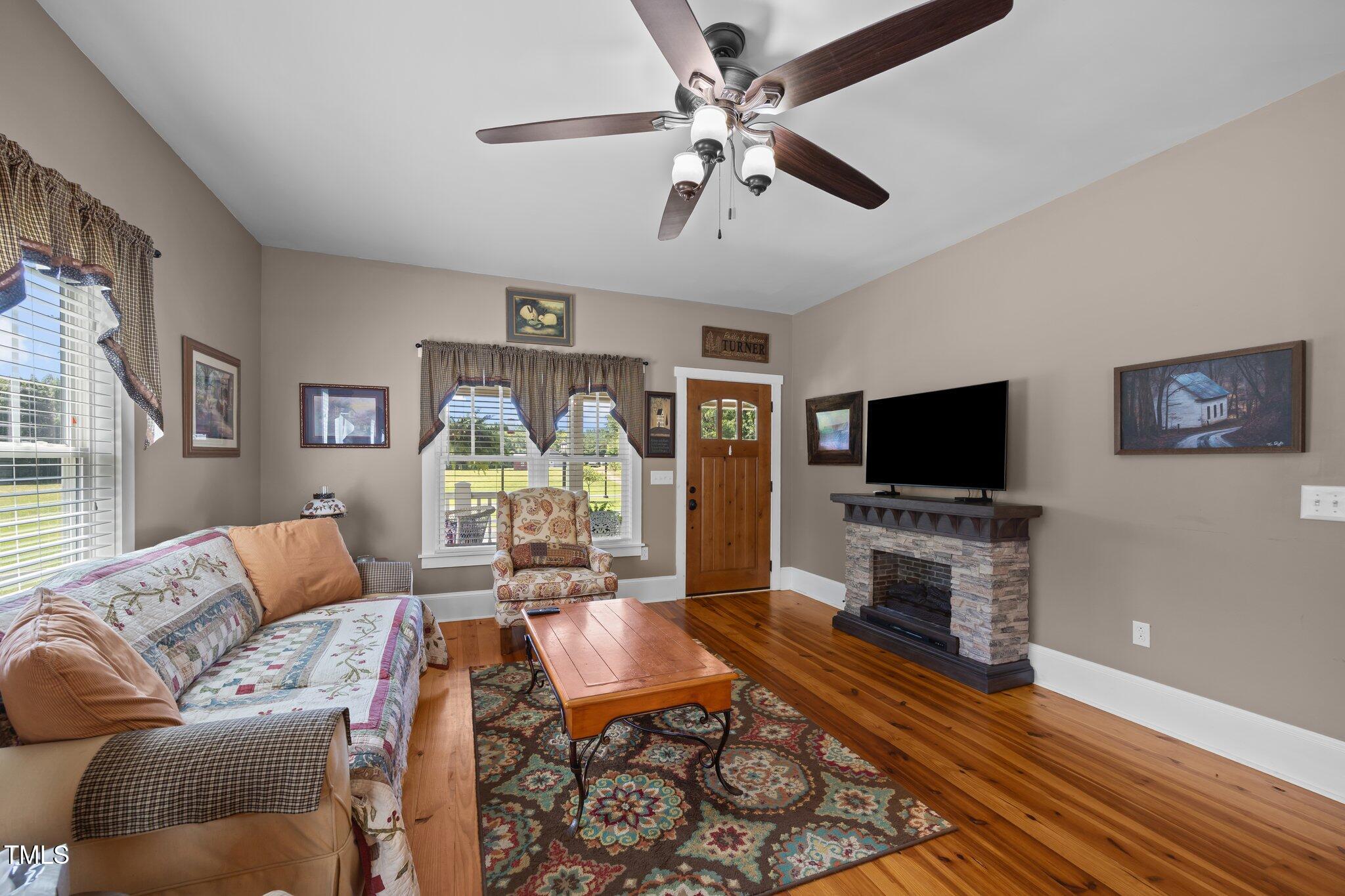4050 Culbreth Road Stem, NC 27581 - Photo 15 of 46 a living room with furniture a flat screen tv and a fireplace