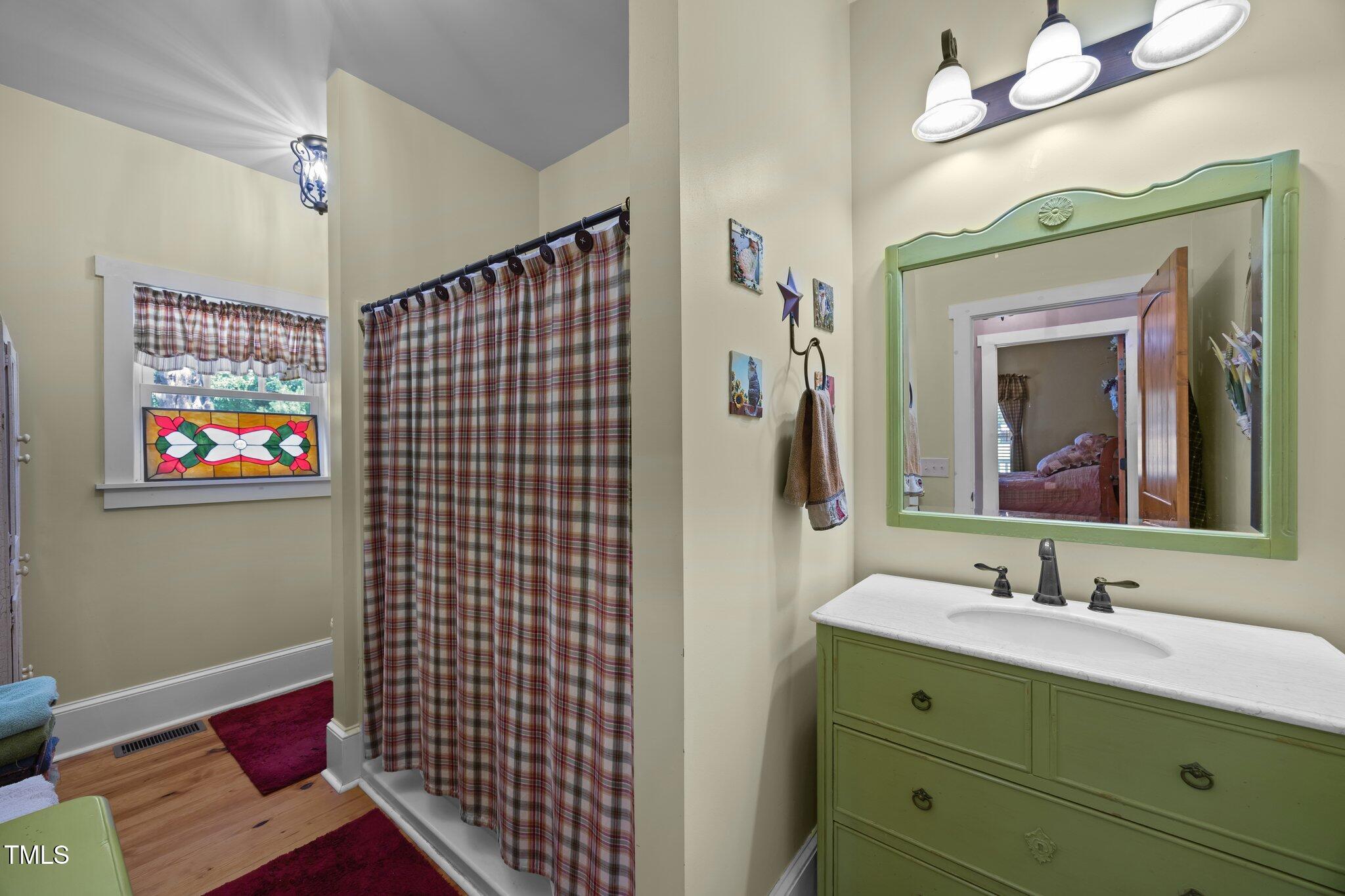 4050 Culbreth Road Stem, NC 27581 - Photo 26 of 46 a bathroom with a sink mirror and a shower