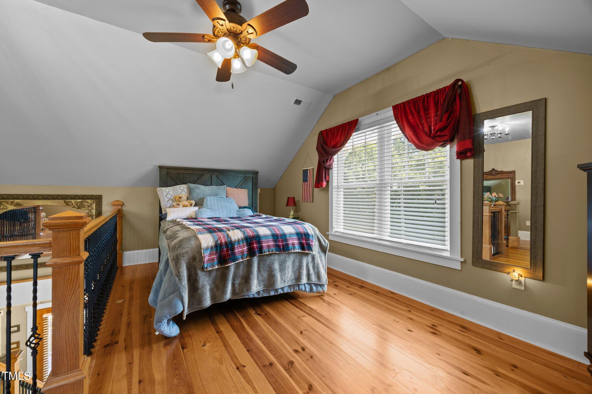 4050 Culbreth Road Stem, NC 27581 - Photo 29 of 46 a bedroom with a bed next to a window and a chandelier
